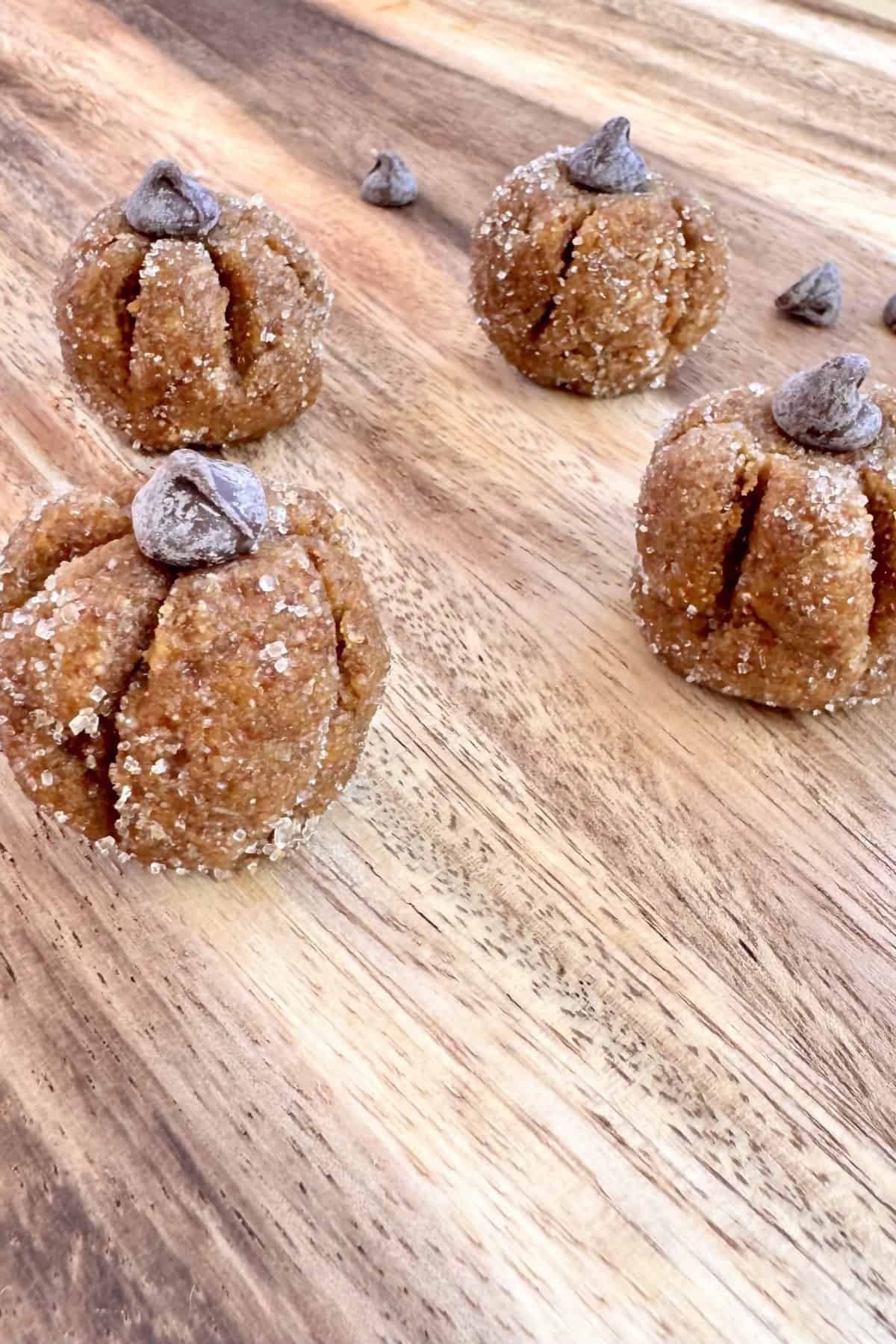set of 4 pumpkin protein energy balls on a wooden board.